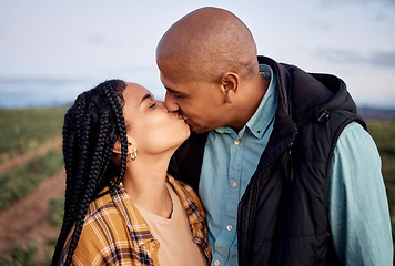 Image showing Agriculture, sustainability and a couple kissing on a farm outdoor for growth in nature during the harvest season. Love, summer or farming with a man and woman sharing a kiss in the countryside