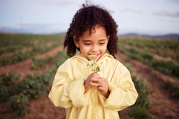 Image showing Children, farm and a girl smelling flowers outdoor in a field for agriculture or sustainability. Kids, nature and spring with a female child holding a flower to smell their aroma in the countryside
