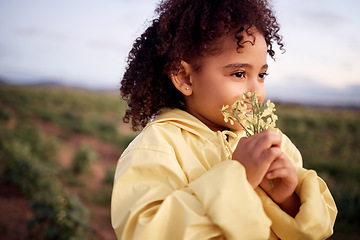 Image showing Children, farm and a girl smelling a flower outdoor in a field for agriculture or sustainability. Kids, nature and spring with a female child holding flowers to smell their aroma in the countryside