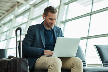 Image showing Airport, business man and laptop for music during travel or working in lobby streaming internet. Entrepreneur person with luggage in building for video call while typing email, search or news