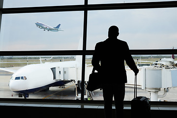 Image showing Airport silhouette, plane travel or man watch airplane fly, flight booking or transportation for world trip. Suitcase luggage, departure or back of person on holiday tour, vacation or global journey