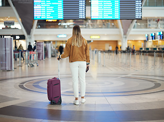 Image showing Woman, airport and luggage checking flight times for travel, vacation or journey with passport in Cape Town. Female traveler standing and waiting ready for departure, boarding plane or immigration