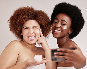 Image showing Skincare, silly and cream with friends and selfie for product, facial and spa. Meme, phone and social media with black women and funny face with lotion for health, makeup and wellness in studio