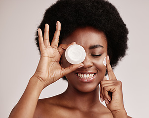 Image showing Skincare, product and black woman with cream on face, afro and excited advertising luxury skin care promotion. Dermatology, spa cosmetics and facial for happy model girl isolated on studio background