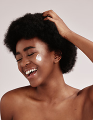 Image showing Skincare, cream on face and black woman with hand on hair, smile and afro, advertising luxury skin product promotion. Dermatology, cosmetics and facial for happy model isolated on studio background.