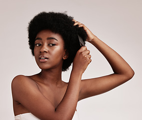 Image showing Afro hair comb, black woman and face of a model with care, salon and cosmetics. Hairdresser, African hairstyle and beauty of a young person doing a treatment for self care in a isolated studio