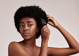 Image showing Afro comb, black woman care of a model with hair care, salon and cosmetics. Hairdresser comb, African hairstyle aesthetic and beauty of a young person doing a treatment for wellness in a studio