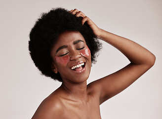 Image showing Skincare, beauty and black woman with collagen eye patches for anti ageing treatment isolated on grey background. Health, skin and model with afro, smile and face mask on eyes, spa facial in studio.