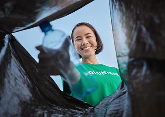 Image showing Recycle, bottle and asian woman with view in bag, sustainability and cleaning plastic pollution, earth day and help with community. Saving the environment, charity and people putting trash in garbage