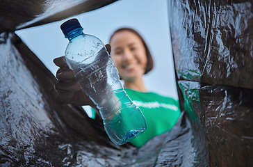 Image showing Recycling, bottle and woman with view in bag, sustainability and cleaning plastic pollution, earth day and community service. Saving the environment, charity and people putting trash in garbage bin