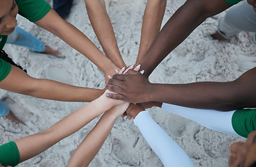 Image showing Teamwork, support and volunteer with hands of people from top at beach for sustainability, environment or climate change. Community, earth day or diversity with friends for recycling, charity or goal