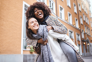 Image showing Girl friends, laugh and city adventure of young people with a piggyback and travel happiness. Freedom, diversity and women smile outdoor feeling happy on a vacation walk on a urban holiday together