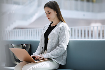 Image showing Research, library or woman student on laptop for internet, communication or blog news in college lobby. Typing, digital or girl sitting on tech for networking, website search or online content review