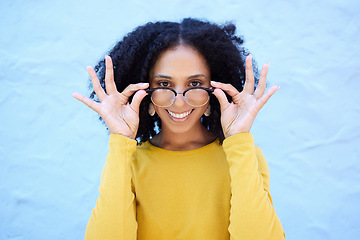 Image showing Spectacle glasses, portrait and black woman on blue background, optical face and trendy cool clothes. Eyewear, smile and happy girl model with vision lenses, yellow color fashion or urban wall mockup