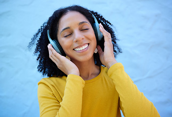 Image showing Black woman, music headphones and smile on wall background, blue backdrop or outdoor. Happy girl listening to radio, podcast and sound of streaming, audio or face of happiness, relax or hearing tech