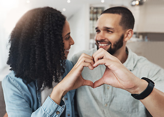 Image showing Love, heart hand sign and happy couple enjoy quality time together, bonding and relax on home living room sofa. Eye contact, emoji gesture and marriage people, man or woman smile in good health