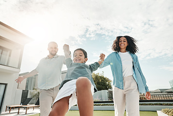 Image showing Children, family and a boy swinging with his parents outdoor in the garden of their home together. Kids, love or playing with a mother, father and son having fun while bonding in the backyard