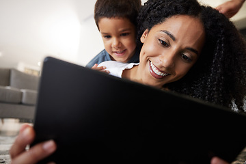 Image showing Love, mother with son on back and on floor with tablet, reading and learning together for quality time. Happy, mama and boy on ground, device and bonding on break, weekend and enjoy online videos