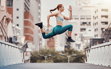 Image showing Workout, jump and health with woman in city for training, cardio and endurance. Energy, fitness and exercise with girl athlete and warm up in urban town for sports, running and body wellness