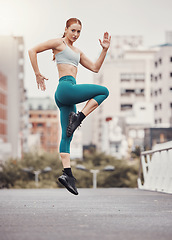 Image showing Warm up, jump and health with woman in city for training, fitness and cardio endurance. Energy, workout and exercise with girl athlete jumping in urban town for sports, running and body wellness