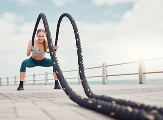 Image showing Fitness, woman and battle rope at the beach for intense arm workout, training or exercise in Cape Town. Active female exercising with ropes for cardio, muscle endurance or power in the outdoors