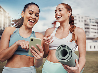 Image showing Yoga, fitness and phone with woman friends laughing at a meme in the park together during exercise. Pilates, social media and training with a female and friend joking outside on a field for a workout