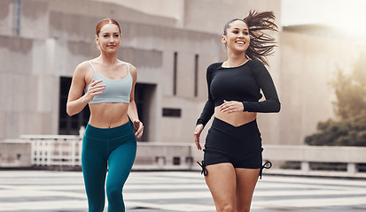 Image showing Women, friends running and together in city for workout, wellness and healthy strong body for teamwork in morning. Woman training group, exercise or runner team in metro with support, smile and happy