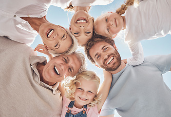 Image showing Happy family, huddle and smile below in trust, community or support together against a blue sky. Portrait of grandparents, parents and children hugging, smiling or bonding for holiday break in nature