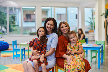 Image showing A child hugging a teacher in a modern kindergarten