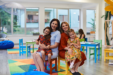 Image showing A child hugging a teacher in a modern kindergarten