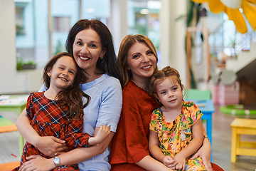 Image showing A child hugging a teacher in a modern kindergarten