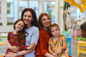 Image showing A child hugging a teacher in a modern kindergarten