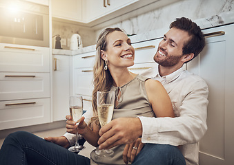 Image showing Celebrate, love and couple with champagne in kitchen for honeymoon, anniversary and valentines day. Happy, relax and young man and woman drinking alcohol on the floor with conversation in marriage