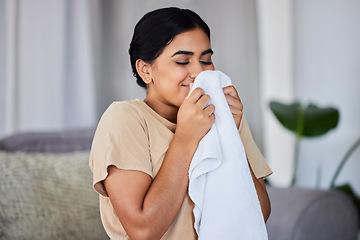 Image showing House, cleaning and woman smelling laundry on a sofa, happy and relax alone in her home. Fresh, linen and smiling domestic worker excited for freshness, results and soft fabric in household chores