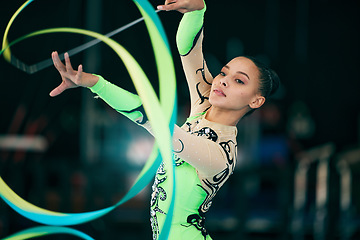 Image showing Sports, gymnastics and female performing with a ribbon for a competition or training in sport arena. Fitness, athlete and woman practicing for balance, endurance and flexibility exercise for routine.