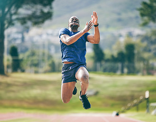 Image showing Black man, high jump and fitness exercise at stadium for training, workout or practice. Sports, wellness and male athlete exercising and jumping for performance, endurance and competition outdoors.