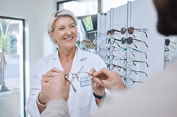 Image showing Glasses, retail store and sale of a senior eye doctor holding a frame to help customer shopping. Happy optometrist, shop wellness and service of an elderly eyes expert with eyeglasses vision check