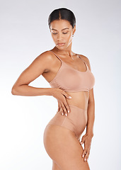 Image showing Black woman, slim body and underwear in fitness, healthy diet or weight loss against a gray studio background. Young African American female model in sexy lingerie, wellness lifestyle or beauty