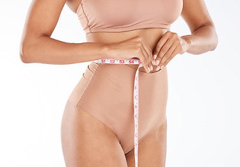 Image showing Tape, fitness body and woman isolated on a white background for lose weight or tummy tuck in underwear. Model person in lingerie, measure waist or stomach for liposuction results or health in studio