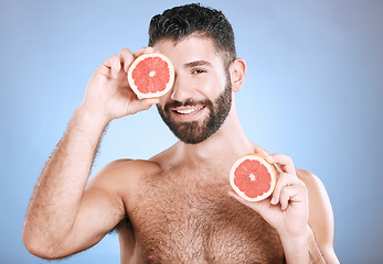 Image showing Portrait, beauty and grapefruit with a man model in studio on a blue background for natural skincare or hygiene. Fruit, wellness and nutrition with a handsome male posing to promote a healthy diet