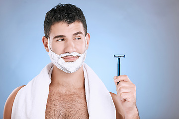 Image showing Facial, foam on beard and man with razor in hand, towel and product placement and mock in studio. Shaving cream on face, hair and skincare for happy male model grooming, isolated on blue background.