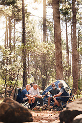 Image showing Man, people and camping in nature for travel, adventure or summer vacation together with chairs and tent in forest. Group of men relaxing and talking enjoying camp out by tall green trees in outdoors