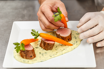 Image showing Chef decorating a pork tenderloin