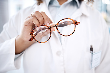 Image showing Glasses, hand and vision with a doctor woman holding a pair of frame eyewear in a clinic for sight correction. Healthcare, medical and insurance with a female optometrist showing prescription lenses