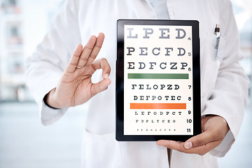 Image showing Hands, tablet screen and snellen chart in hospital for vision examination in clinic. Healthcare, ok gesture or woman, ophthalmologist or medical doctor holding technology showing letters for eye test