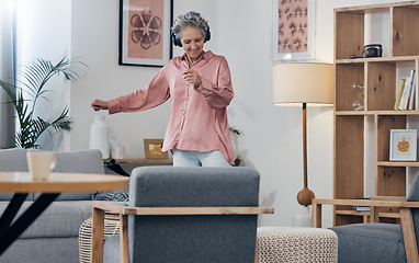 Image showing Mature, music and woman with headphones for dance, freedom and streaming audio in the lounge. Fun, enjoyment and dancing elderly person with a podcast, radio or listening to a sound for happiness