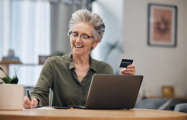 Image showing Laptop, credit card and senior woman paying her bills, debt or mortgage with online banking. Elderly lady planning a financial investment or calculating her retirement finances on paper at her home.