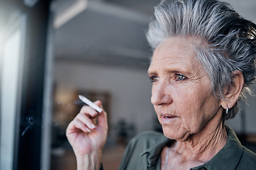 Image showing Thinking, nicotine and a senior woman smoking a cigarette in her home while looking out from a window. Idea, smoke and cancer with a mature female tobacco smoker in a house for pension or retirement