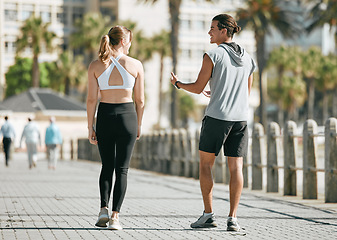 Image showing Fitness, teamwork or health with a runner couple on the promenade for cardio or endurance from the back. Exercise, wellness or workout with a man and woman athlete running outdoor in the city