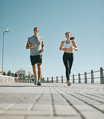 Image showing Couple, fitness and running by beach in the city for exercise, workout or cardio routine together. Happy man and woman runner taking a walk or jog for healthy wellness or exercising in Cape Town